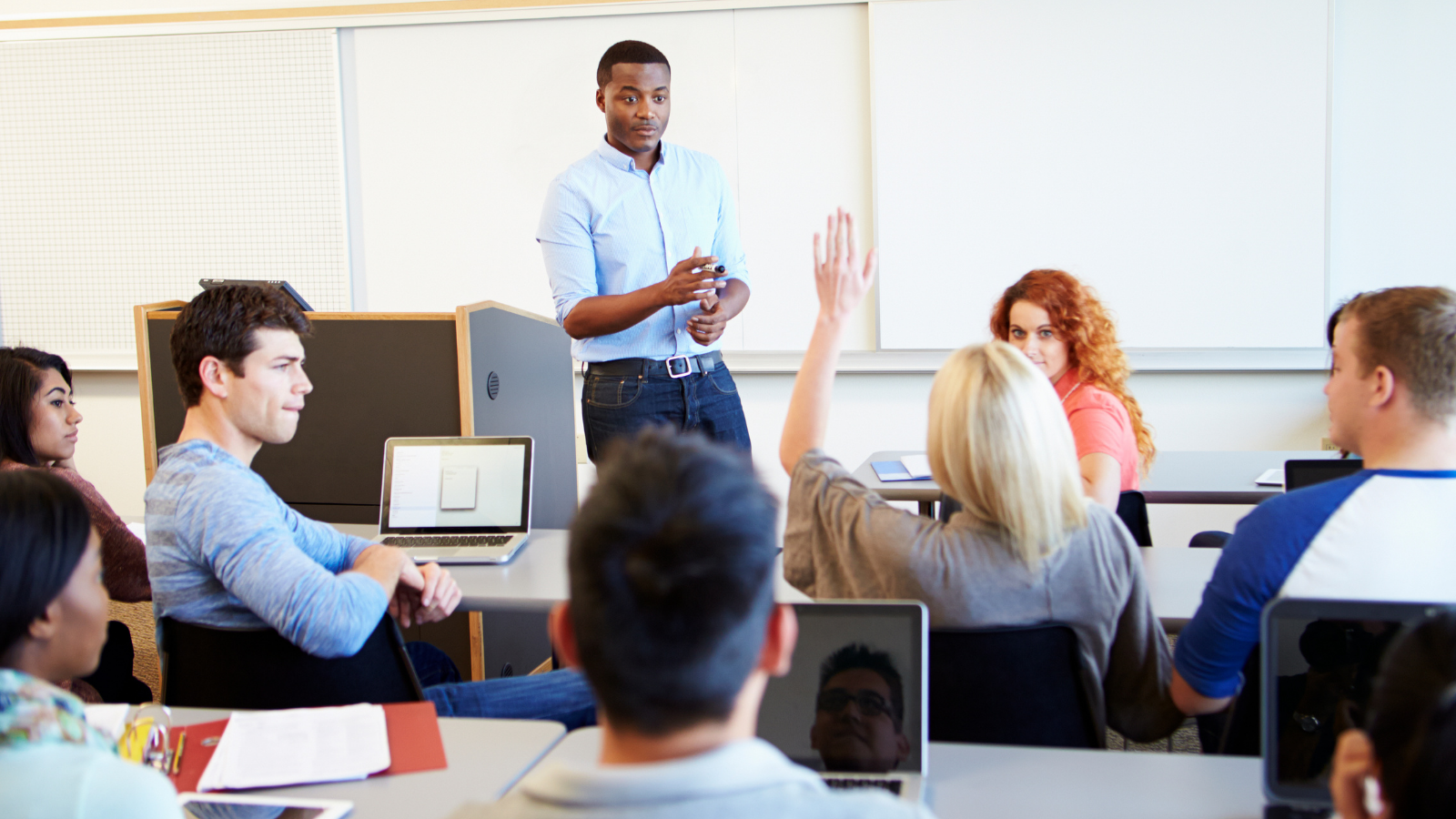 image of man teaching three students who are seated in the room