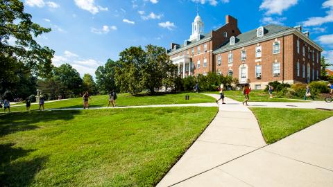 A shot of HJ Patterson Hall with students passing in front of it on sidewalk