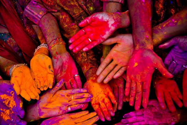 hands with orange and yellow paint on them palms up